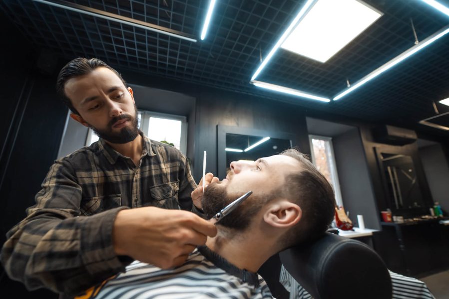 hairdresser-doing-haircut-of-beard-using-comb-and-2021-12-09-22-33-26-utc.jpg